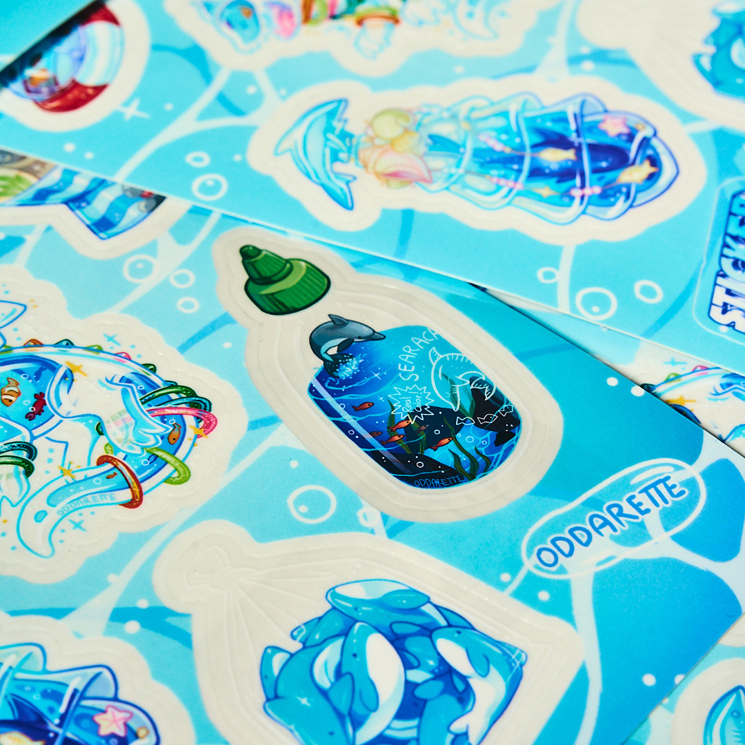 Sticker sheets printed on transparent with a sriratcha bottle, cartoony designs, and "oddarette" written.