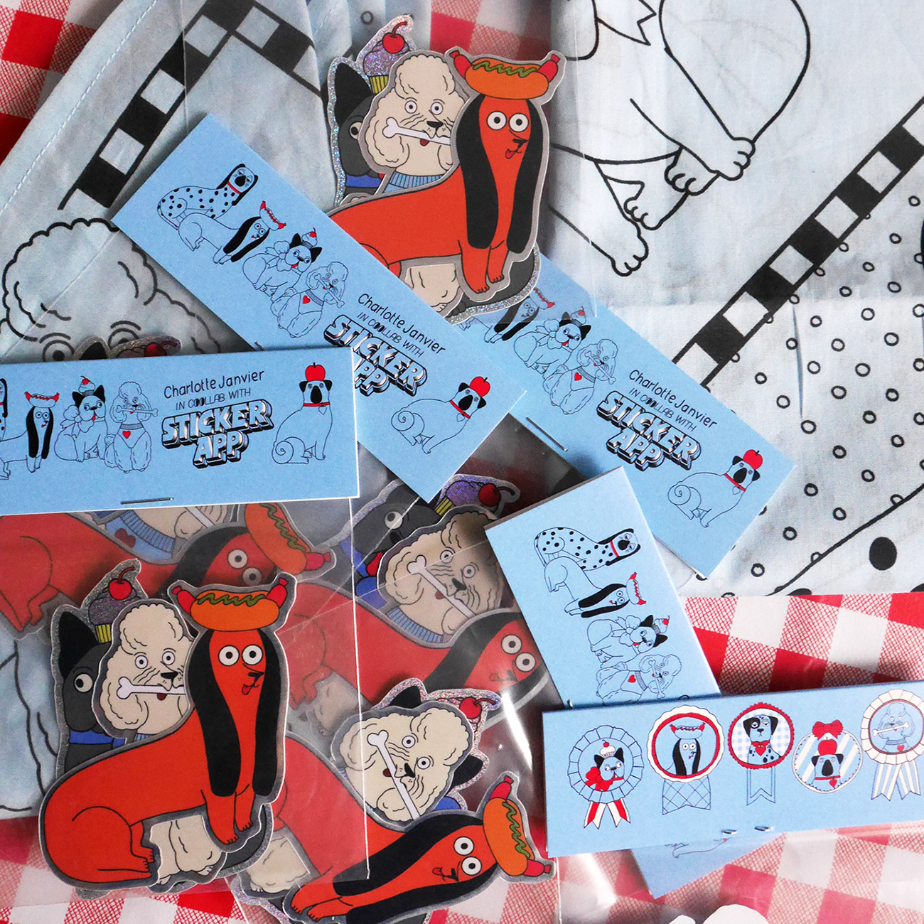 Stickers of a cartoon dachshund and various animals, displayed on a blue background and checkered cloth.