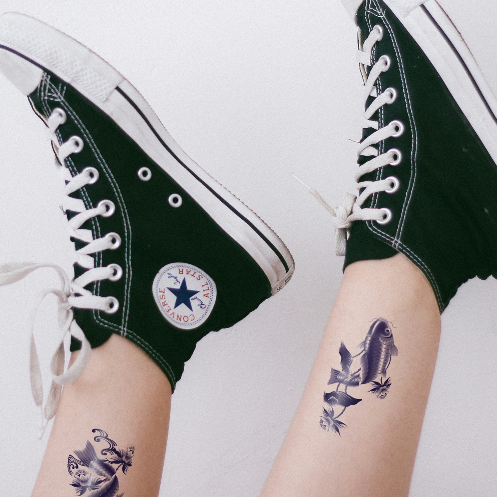 Temporary tattoo of a detailed black fish design applied on a person’s lower leg, with black high-top sneakers visible in the frame
