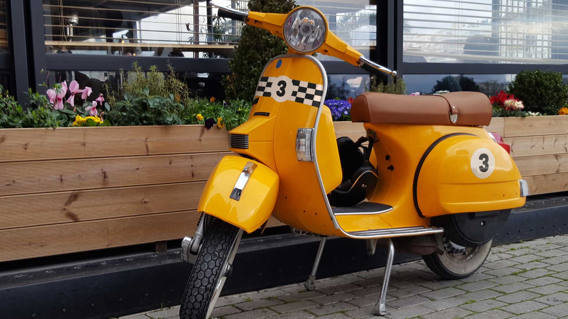 Custom number stickers on a yellow scooter.