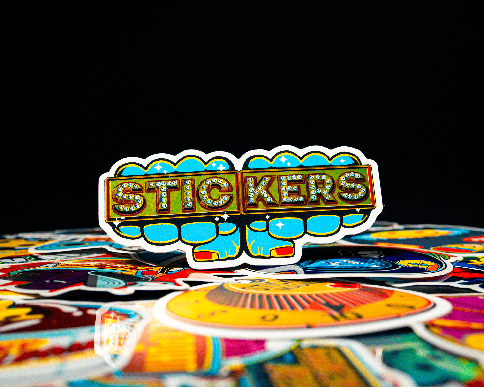 A colorful sticker that is knuckels with brass knuckels that say "STICKERS"
