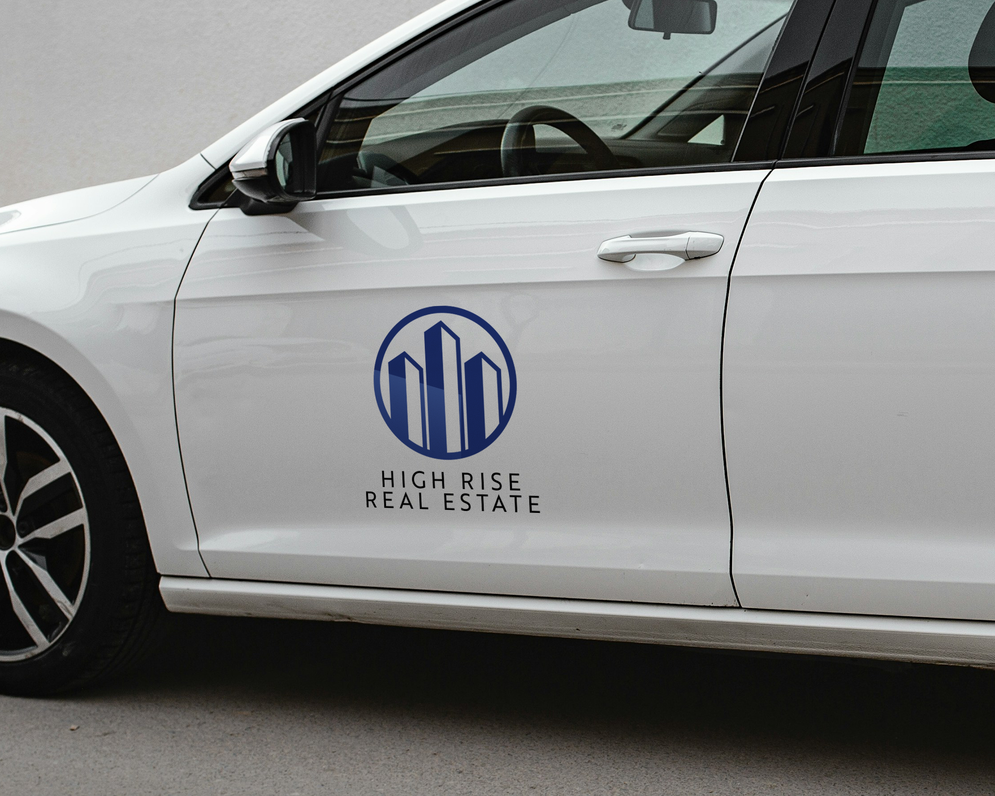 Custom business decal featuring a blue real estate logo applied to the side door of a white car.