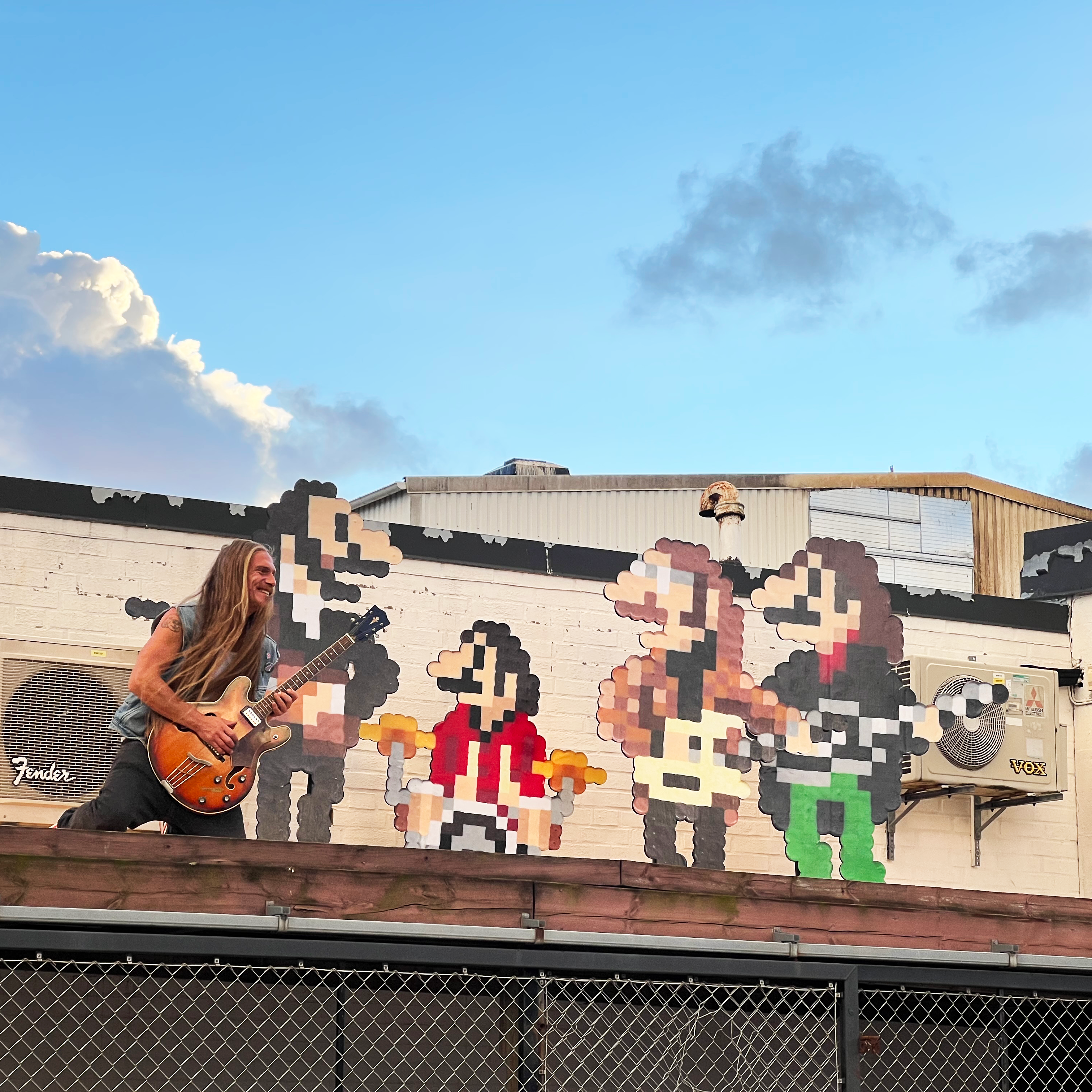 Large-scale vinyl stickers of the Beatles playing on rooftop together with a real person