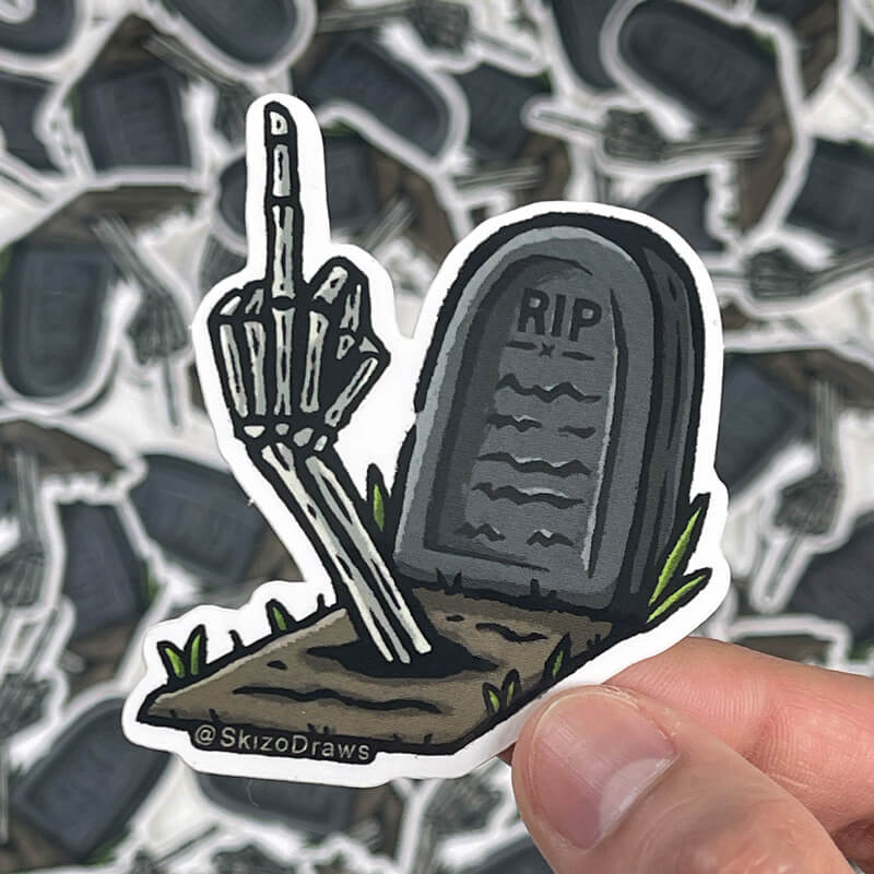 Vinyl die-cut sticker of a tomb with the text "RIP" and a skeleton arm raising its middle finger from the ground, against a background of stickers.